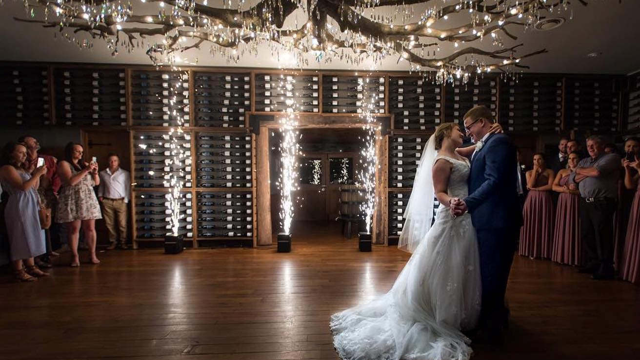 Bride and groom dancing with indoor cold sparks during their wedding reception.